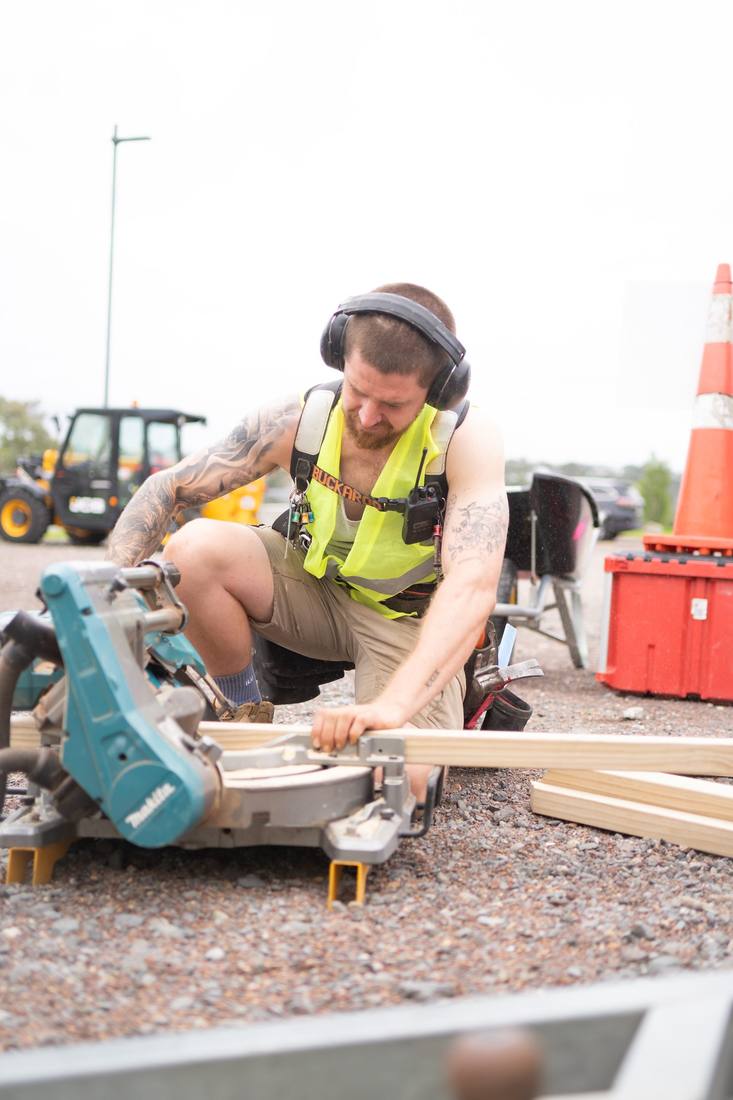 Builder cutting timber on a drop saw