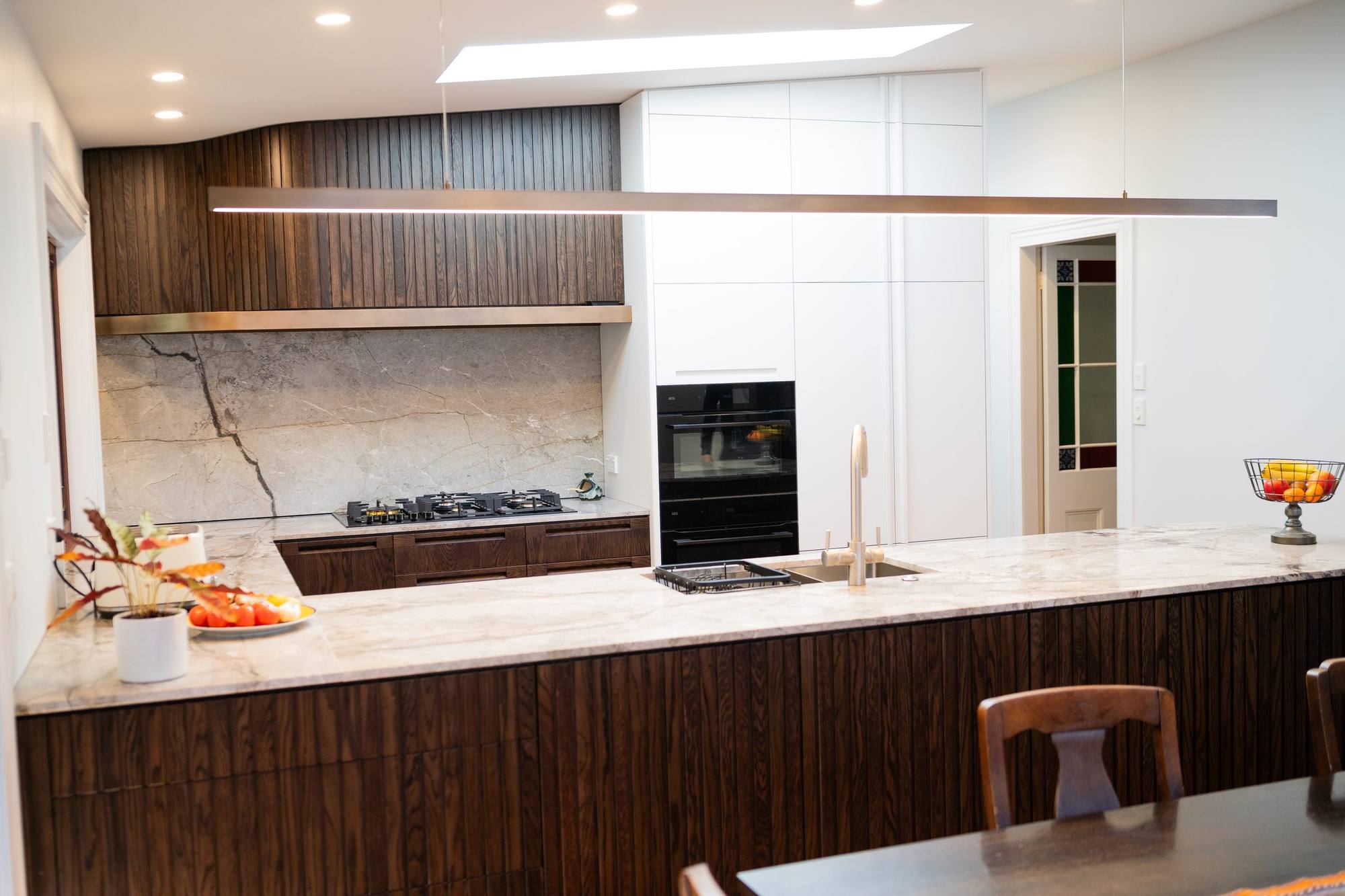 A finished kitchen renovation with dark timber battens and a marble benchtop