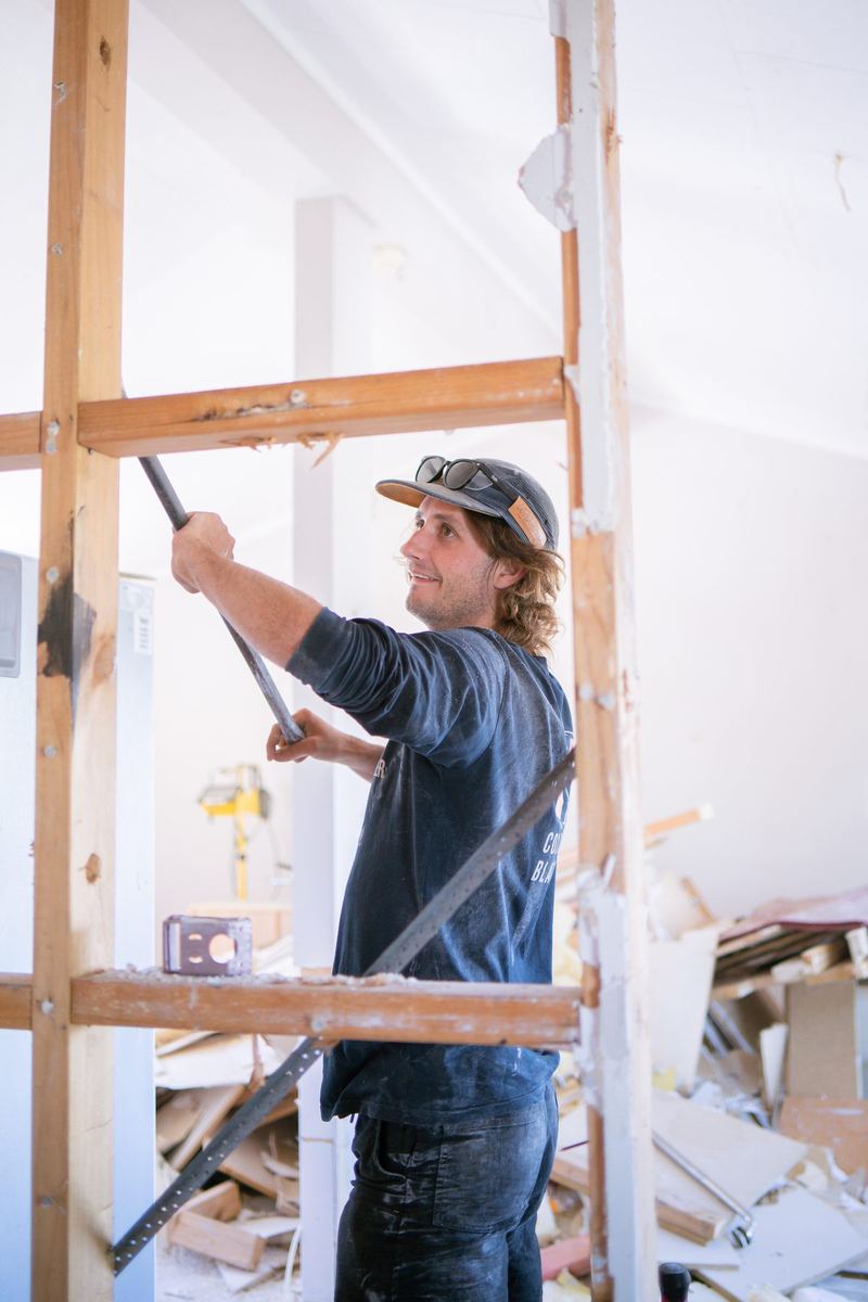 Builder pulling out old framing during a strip-out