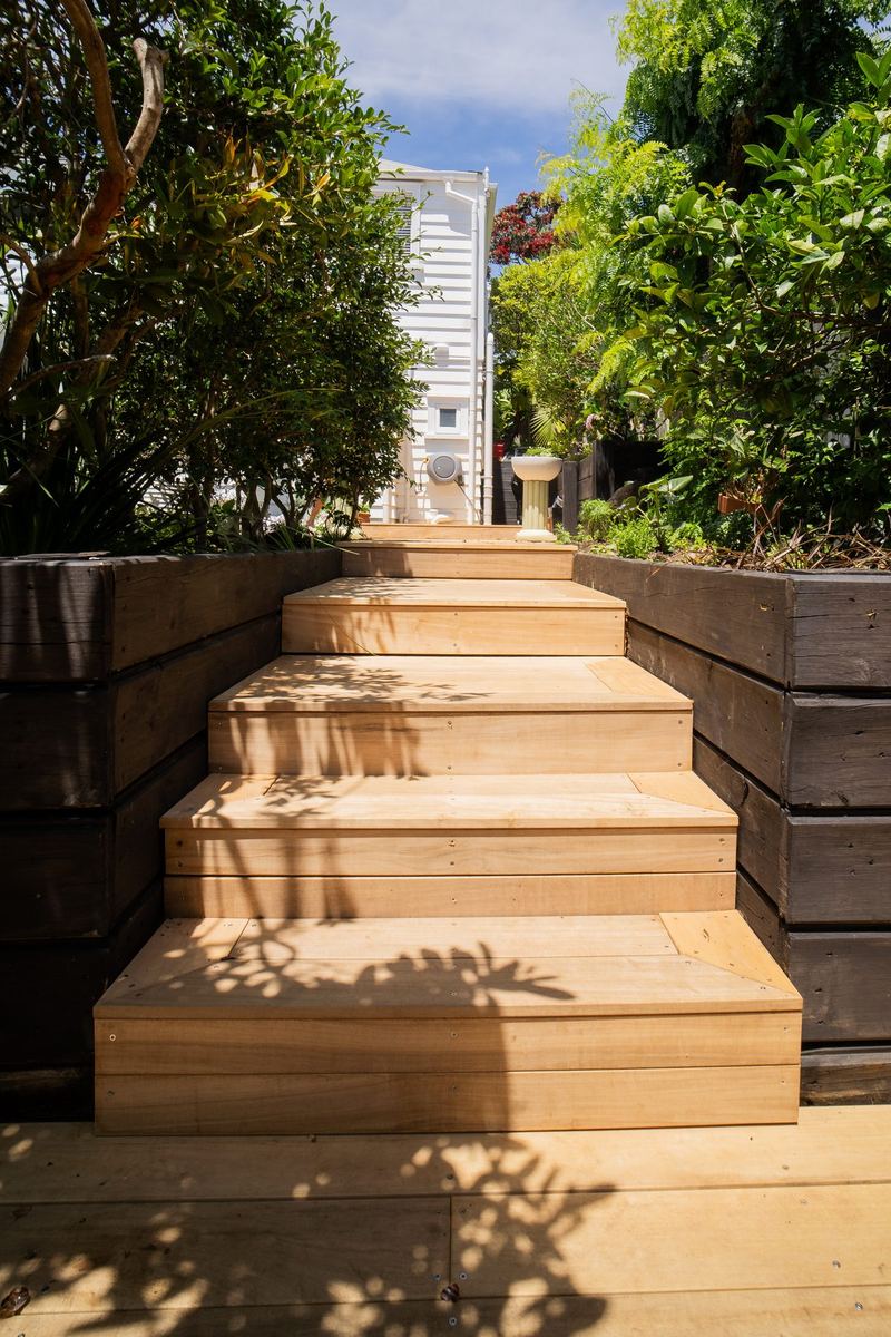 Hardwood garden steps between black sleeper walls