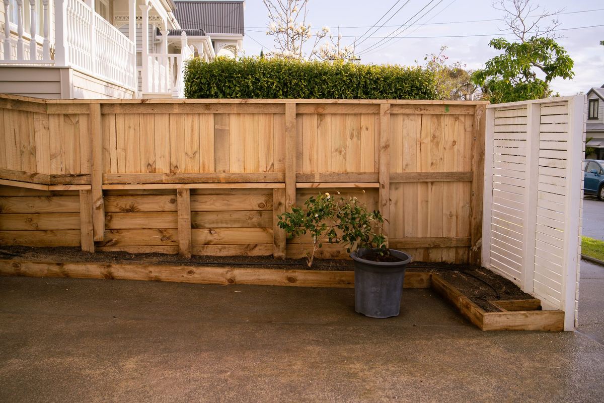 New timber retaining wall and fence with a planter box along the driveway